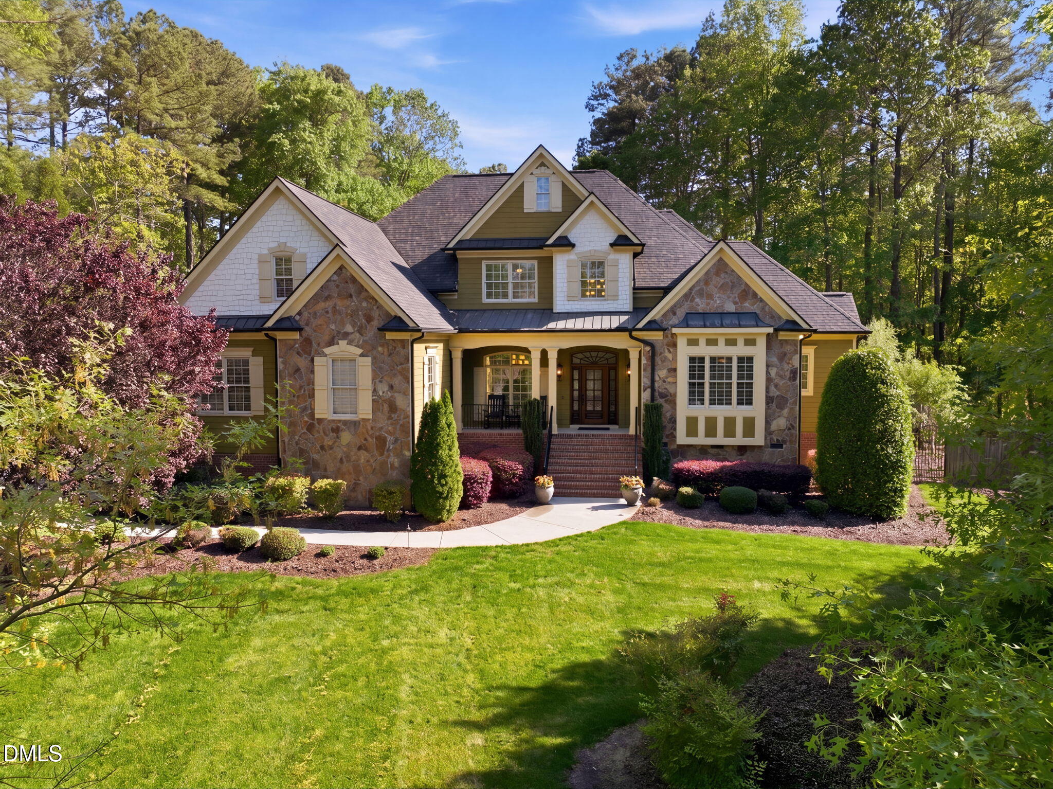 a front view of a house with a yard and trees