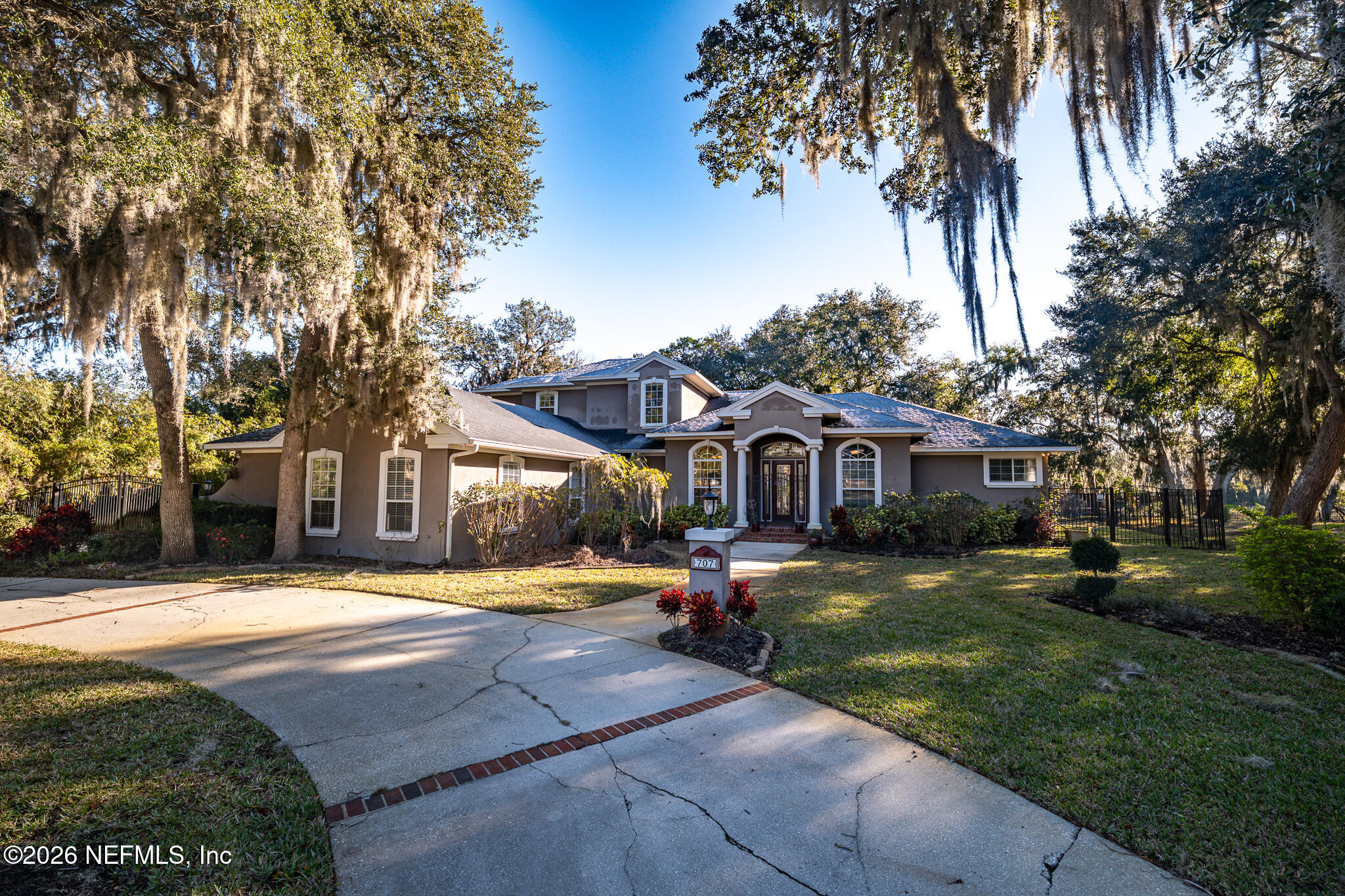 a front view of a house with a yard and trees