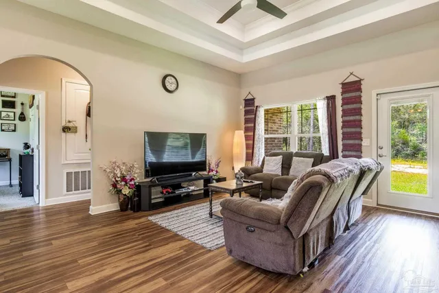 a dining room with furniture a chandelier and wooden floor