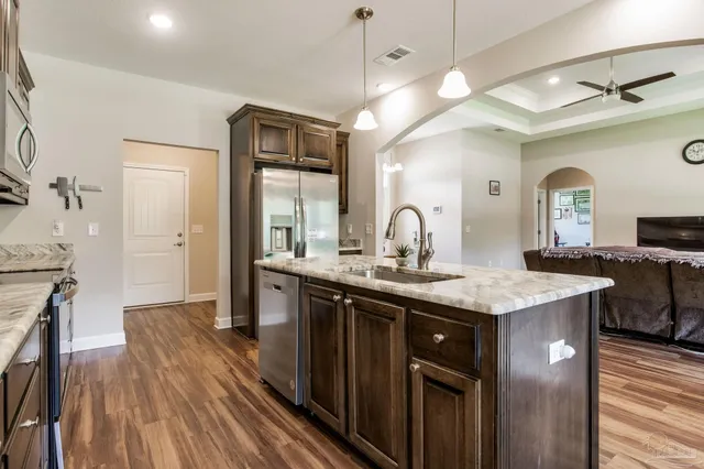 a bathroom with a granite countertop sink mirror and cabinets