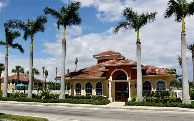 a front view of a house with a garden and palm trees