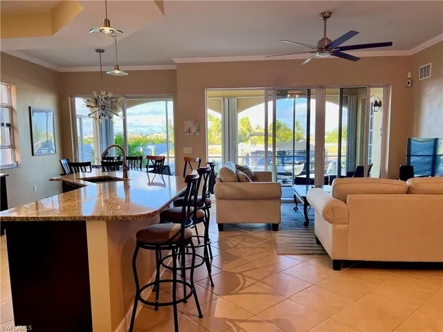 a living room with couches a fireplace and a dining table with a large window