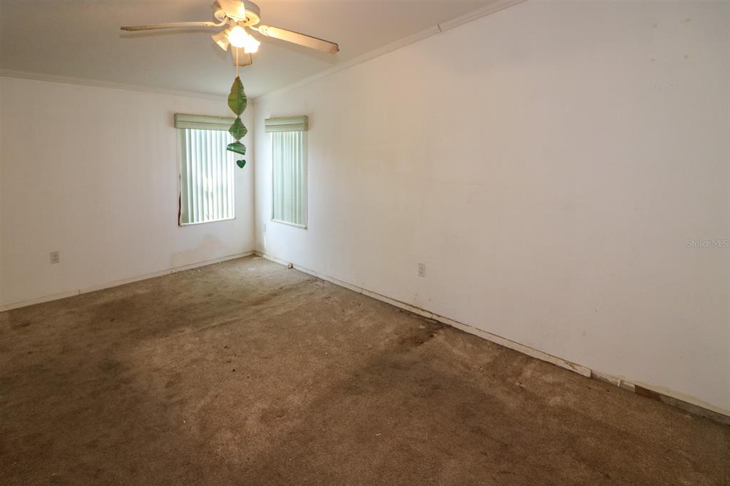29200 South Jones Loop Road, Unit 205 Punta Gorda, FL 33950 - Photo 14 of 25 an empty room with a chandelier fan and windows