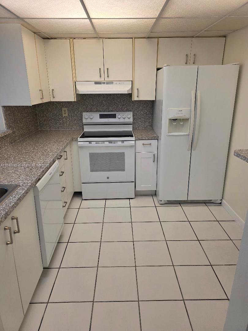 1121 Southwest 105th Avenue, Unit 322 Miami, FL 33174 - Photo 1 of 19 a kitchen with cabinets and a stove top oven