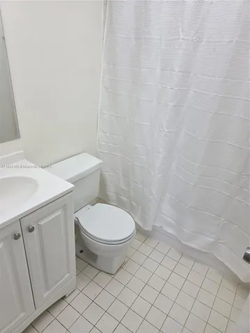 a white toilet sitting next to a white sink