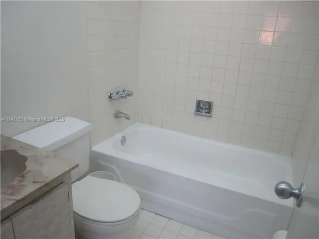 a white toilet sitting next to a bath tub