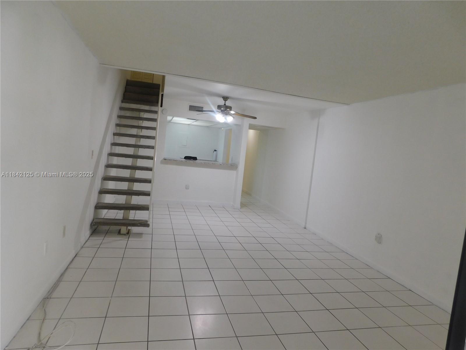 1121 Southwest 105th Avenue, Unit 322 Miami, FL 33174 - Photo 8 of 19 a view of an empty room with stairs