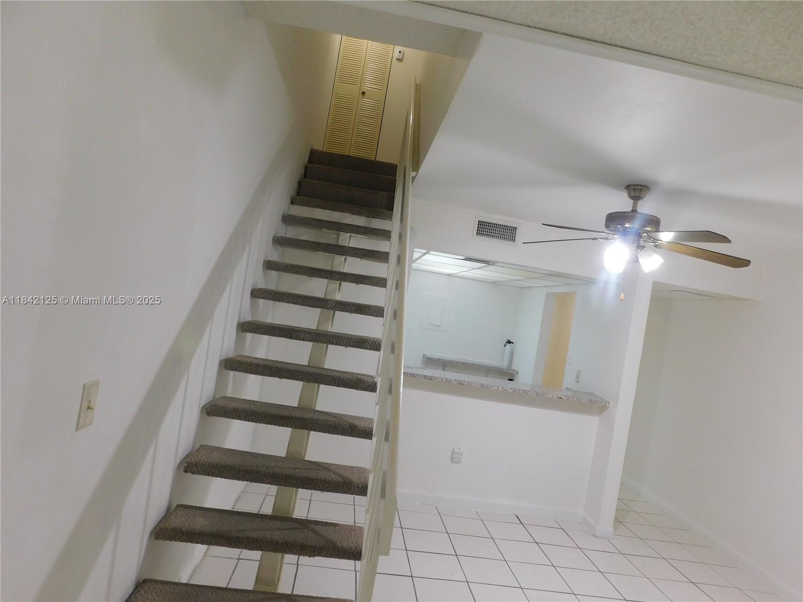 1121 Southwest 105th Avenue, Unit 322 Miami, FL 33174 - Photo 9 of 19 a view of staircase with white walls and windows