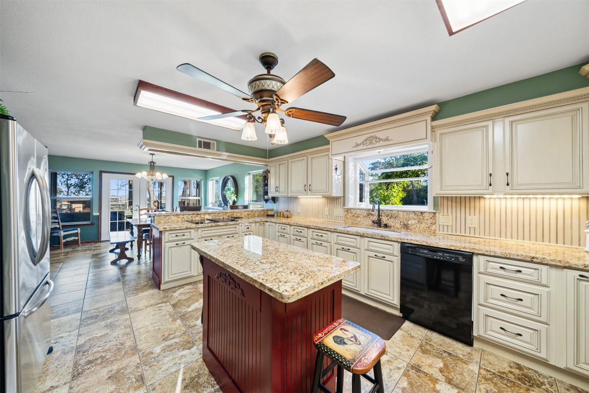 25948 Nelson Road Hempstead, TX 77445 - Photo 11 of 50 a kitchen with a stove a sink a dining table and chairs