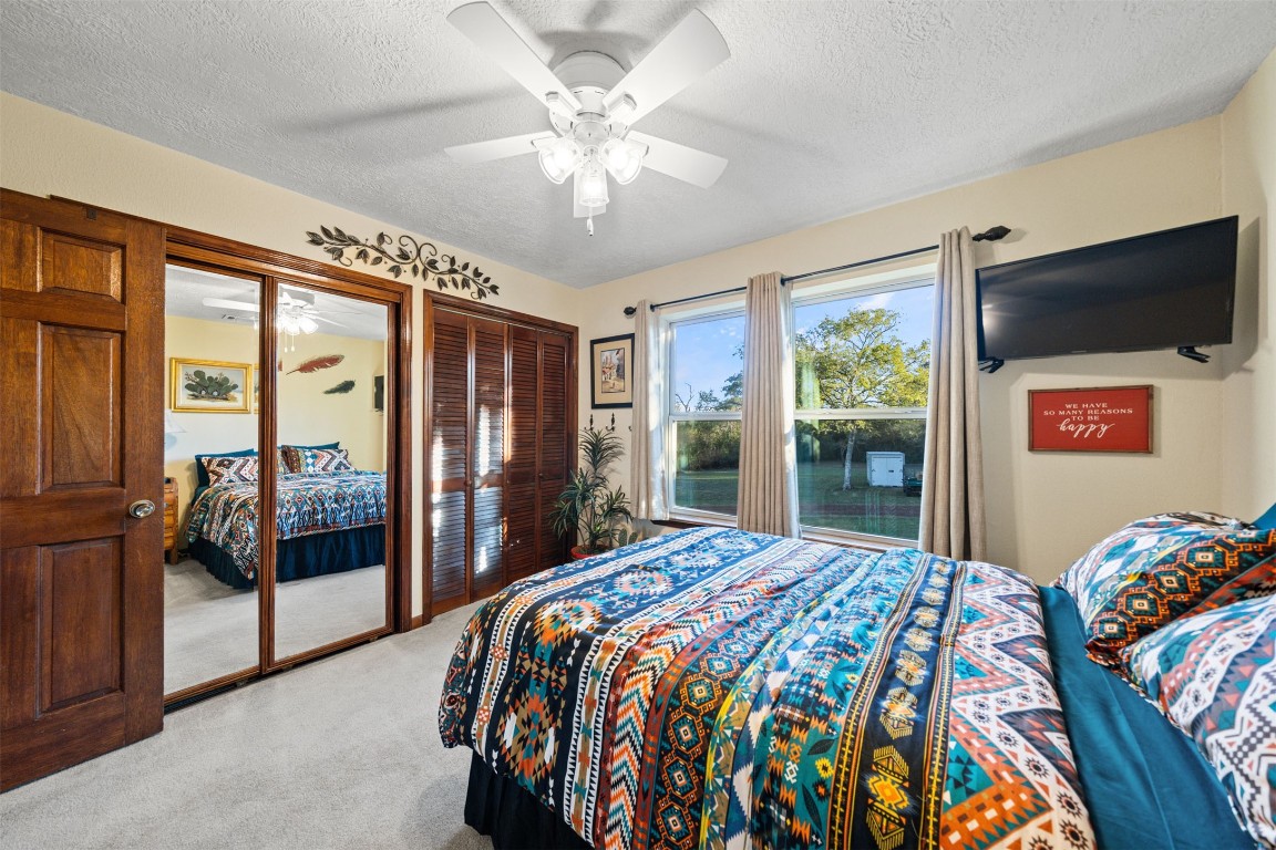 25948 Nelson Road Hempstead, TX 77445 - Photo 29 of 50 a bedroom with a large bed and a flat tv screen