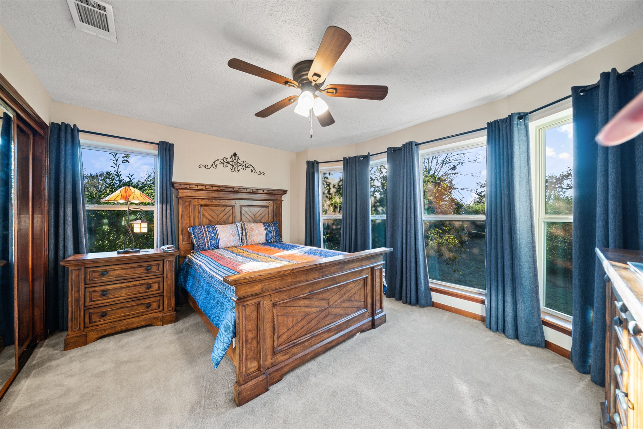 25948 Nelson Road Hempstead, TX 77445 - Photo 29 of 50 a bedroom with a large bed and a chandelier fan