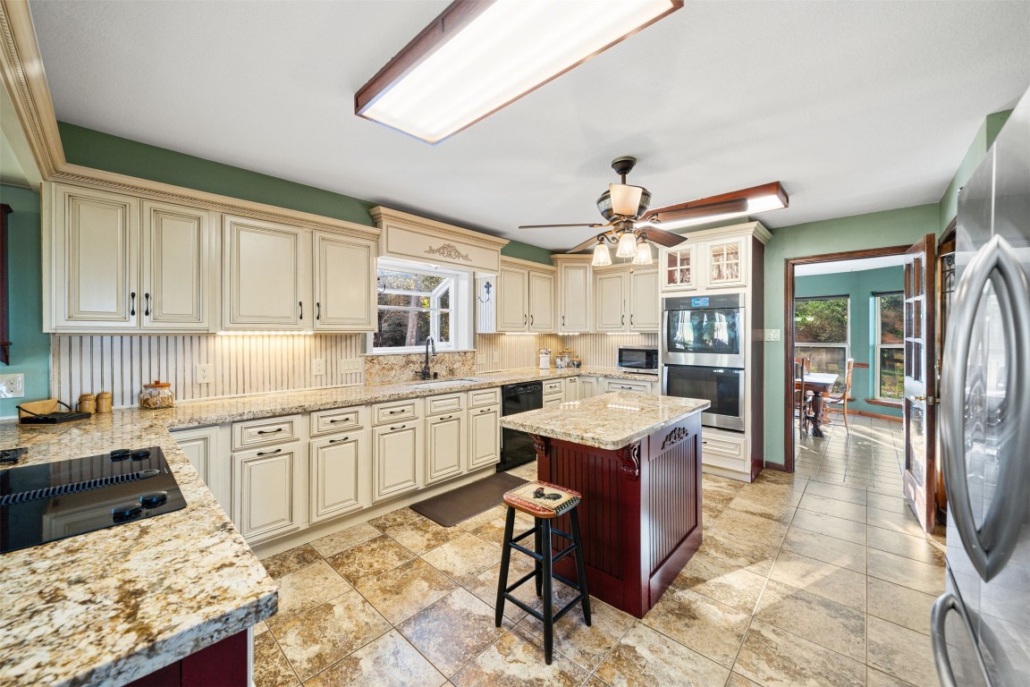 25948 Nelson Road Hempstead, TX 77445 - Photo 6 of 50 a kitchen with granite countertop sink cabinets and refrigerator