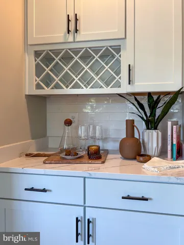 a kitchen with stainless steel appliances kitchen island granite countertop a refrigerator a stove and white cabinets with wooden floor