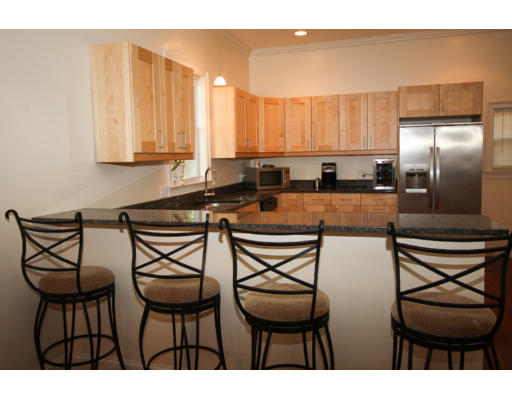 10 Beacon Street, Unit 1 Chelsea, MA 02150 - Photo 8 of 17 a kitchen with stainless steel appliances kitchen island granite countertop a table and chairs