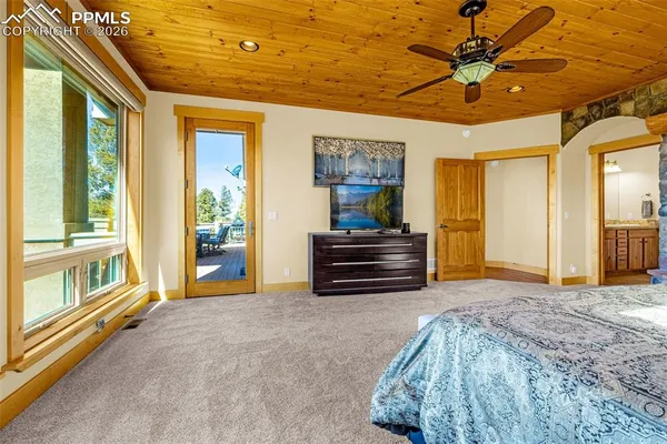 a spacious bedroom with a bed and a chandelier