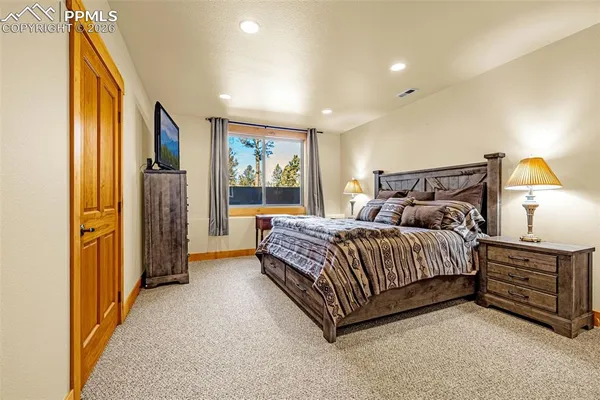 a spacious bedroom with a bed and a painting on the wall