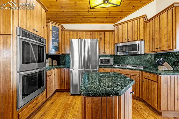 a kitchen with stainless steel appliances granite countertop a stove a sink and a microwave