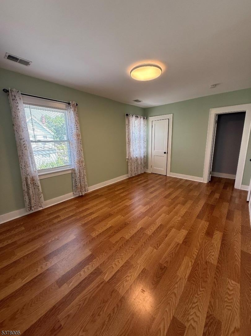 588 Chestnut Street, Unit 2 Orange, NJ 07050 - Photo 7 of 16 a view of an empty room with wooden floor and a window