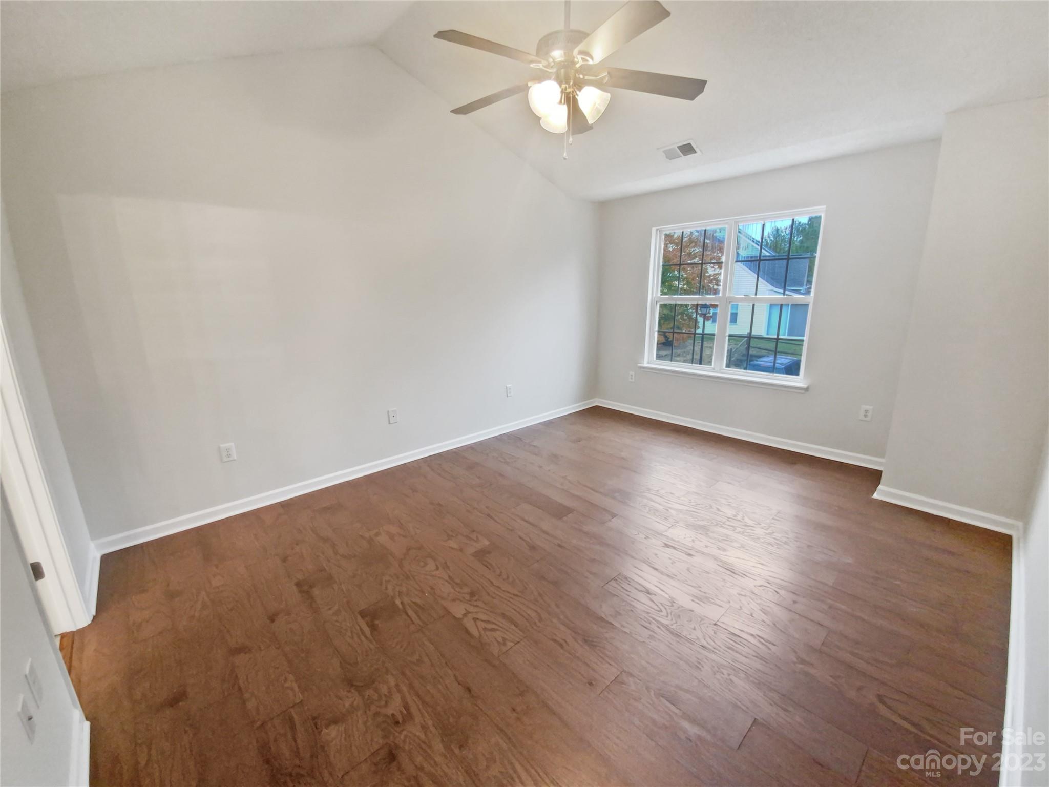 414 Robin Reed Court Pineville, NC 28134 - Photo 21 of 27 a view of an empty room with wooden floor and a window