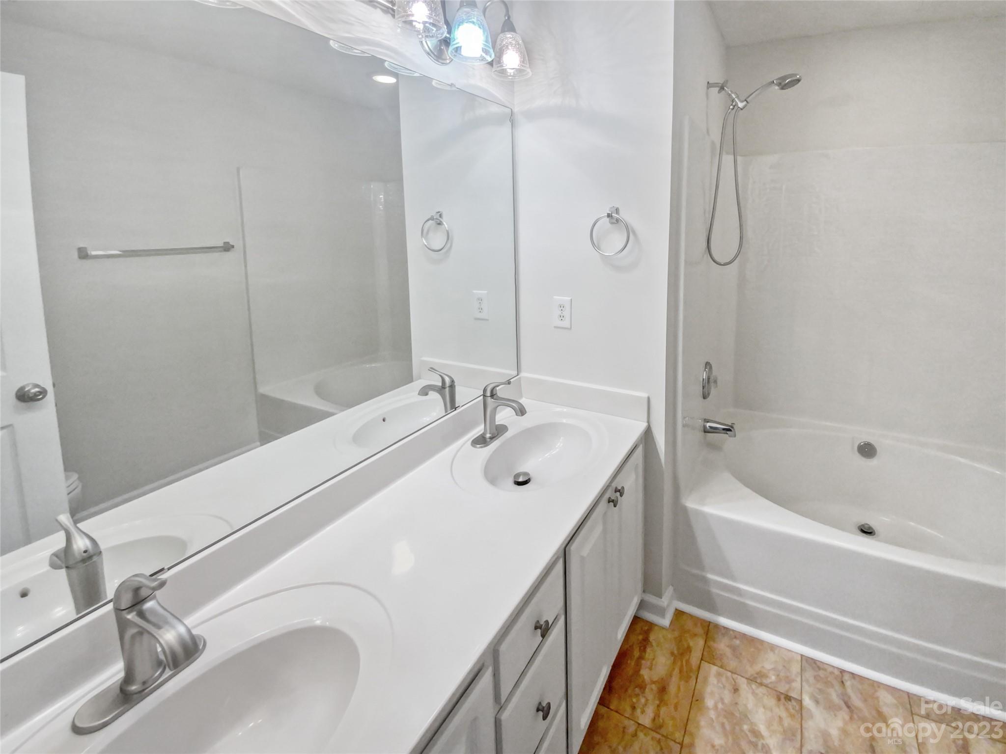 414 Robin Reed Court Pineville, NC 28134 - Photo 23 of 27 a bathroom with a tub sink and mirror