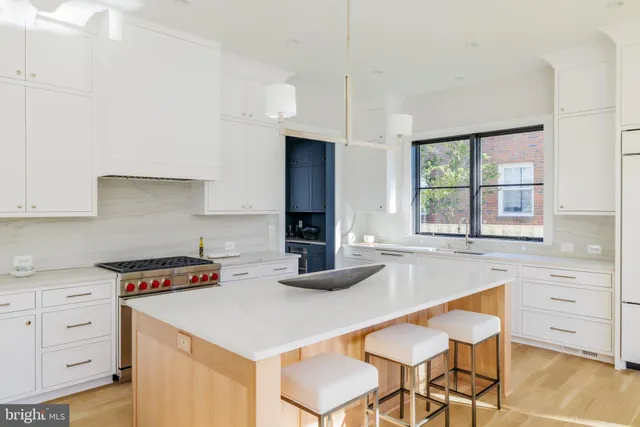 a kitchen with white cabinets and appliances
