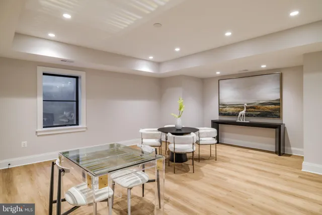 a living room with a table and chairs with wooden floor