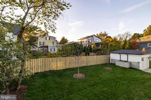 a view of a house with backyard and wooden fence