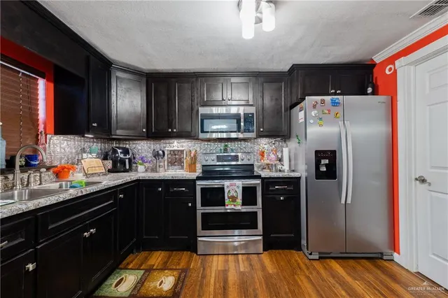 a kitchen with stainless steel appliances a refrigerator and a sink