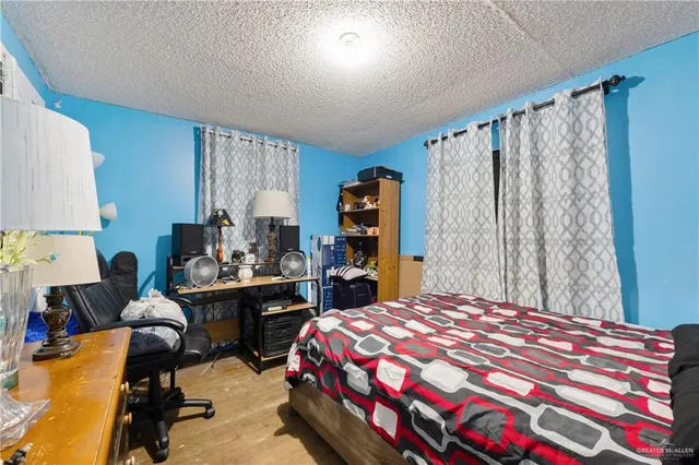 a bedroom with a bed and dresser with mirror