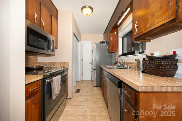 a kitchen with stainless steel appliances granite countertop a stove a sink and a microwave