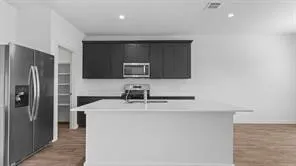 a kitchen with stainless steel appliances a refrigerator a sink a stove a microwave and cabinets