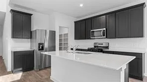 a kitchen with a sink a microwave a refrigerator and cabinets