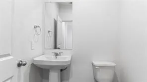 a bathroom with a sink a toilet and a mirror