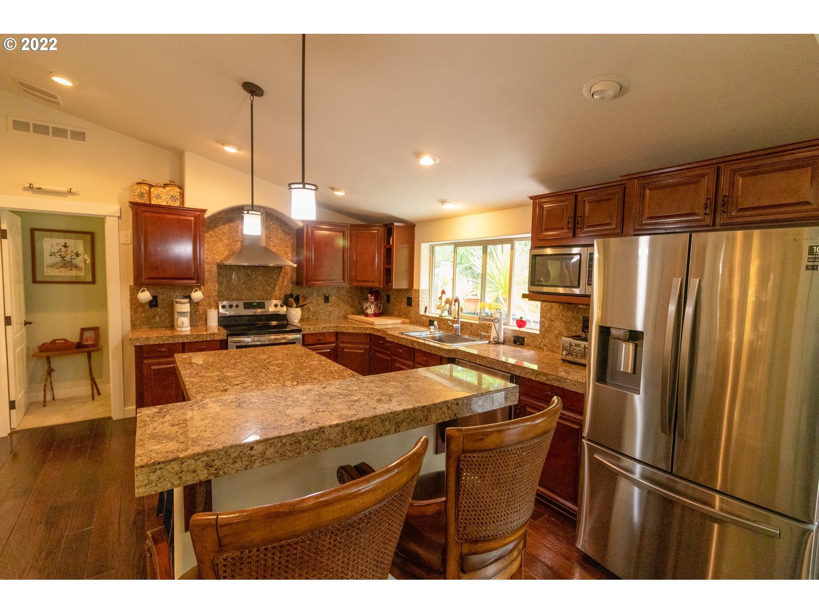 5732 Nicholson Road Florence, OR 97439 - Photo 13 of 31 a kitchen with stainless steel appliances kitchen island granite countertop a refrigerator a stove and a sink