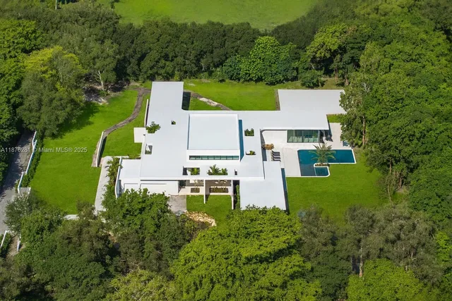 an aerial view of a house with garden space and trees