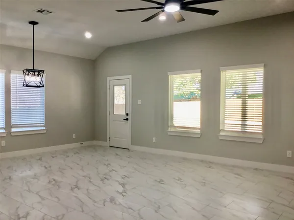a view of an empty room with kitchen stove and refrigerator
