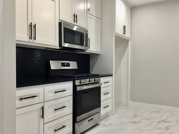 a kitchen with stainless steel appliances granite countertop a stove microwave and sink
