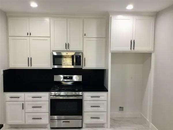 a kitchen with stainless steel appliances a stove microwave and cabinets