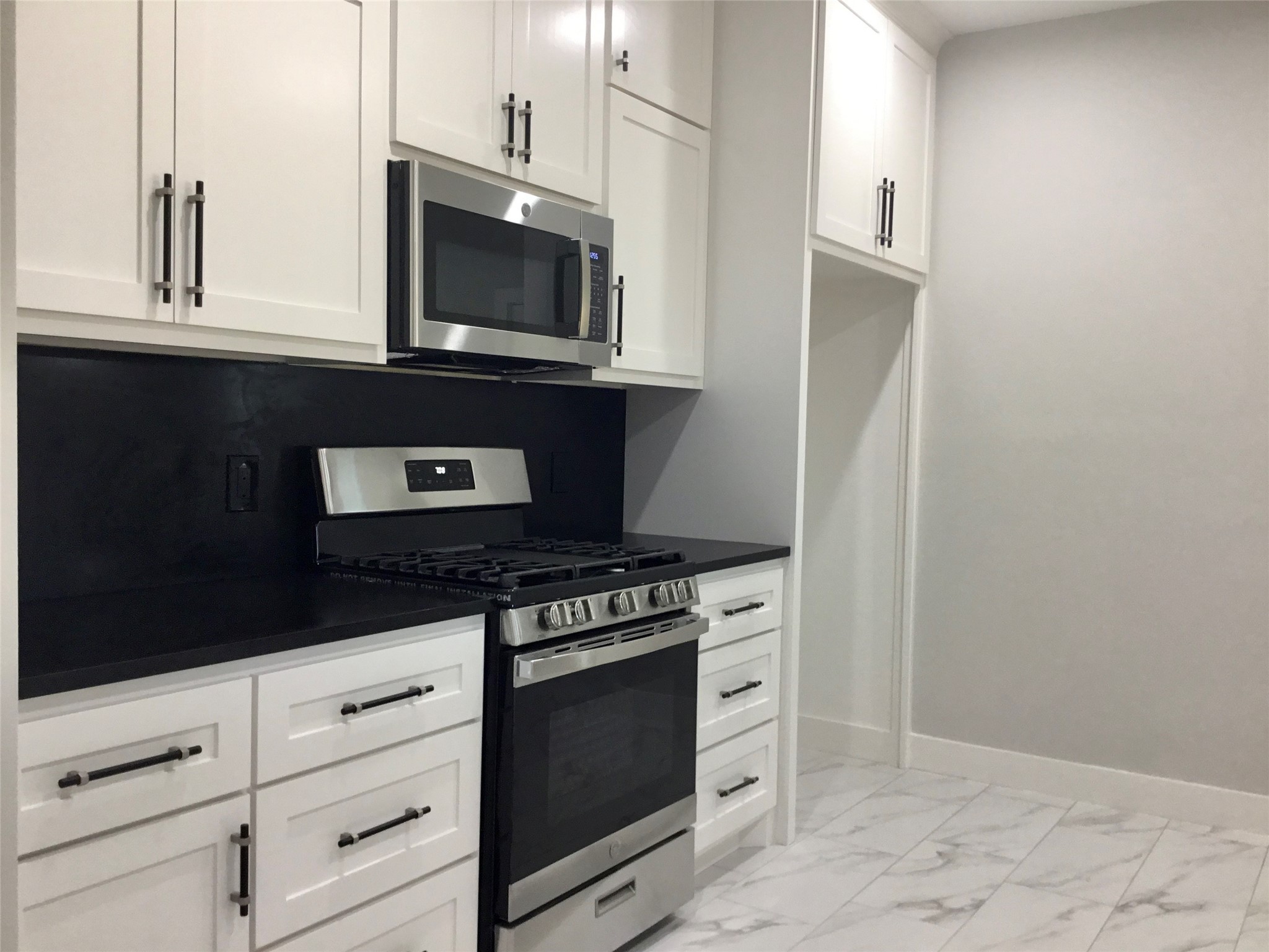 924 East 2nd Street Bellville, TX 77418 - Photo 9 of 38 a kitchen with stainless steel appliances a stove microwave and cabinets