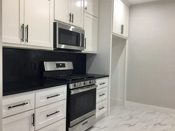 a kitchen with a sink and white cabinets