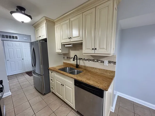 a kitchen with stainless steel appliances granite countertop a refrigerator and a sink