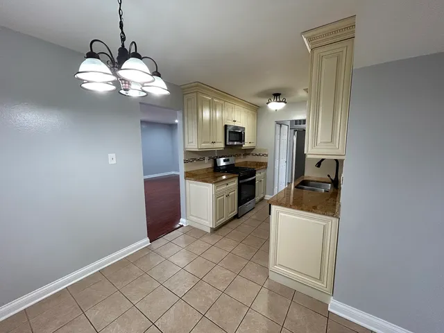 a kitchen with kitchen island granite countertop stainless steel appliances a stove a sink and a refrigerator