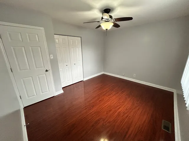 a view of a room with wooden floor and ceiling fan