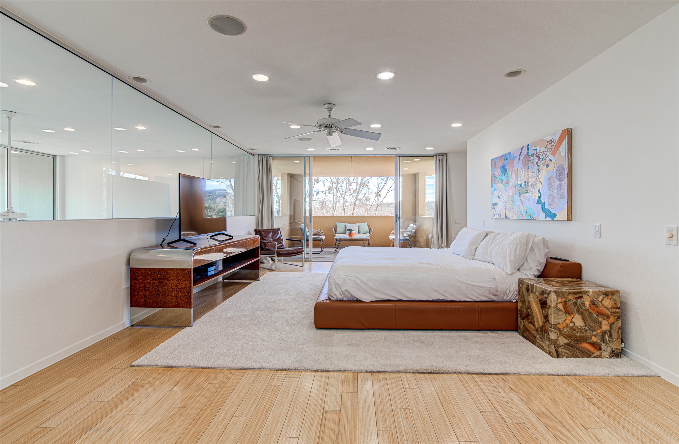 9707 Timber Ridge Pass Austin, TX 78733 - Photo 8 of 18 Warm wood flooring pairs beautifully with sliding glass doors opening to a private balcony.