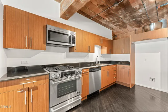 a kitchen with granite countertop stainless steel appliances and wooden cabinets