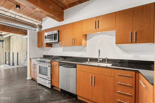 a kitchen with stainless steel appliances granite countertop a stove a sink and a microwave