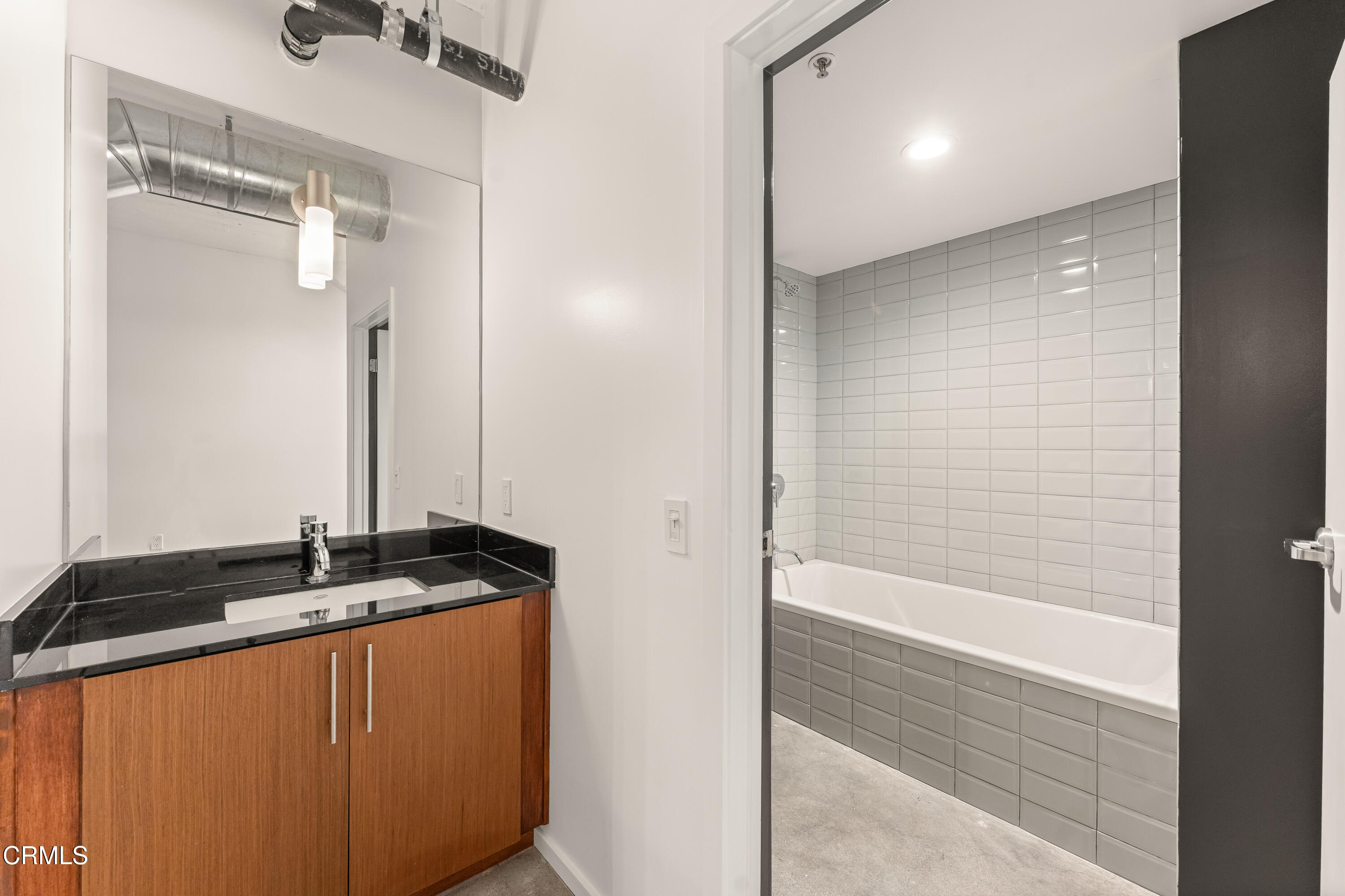 530 South Hewitt Street, Unit 130 Los Angeles, CA 90013 - Photo 44 of 53 a bathroom with a granite countertop sink and a mirror