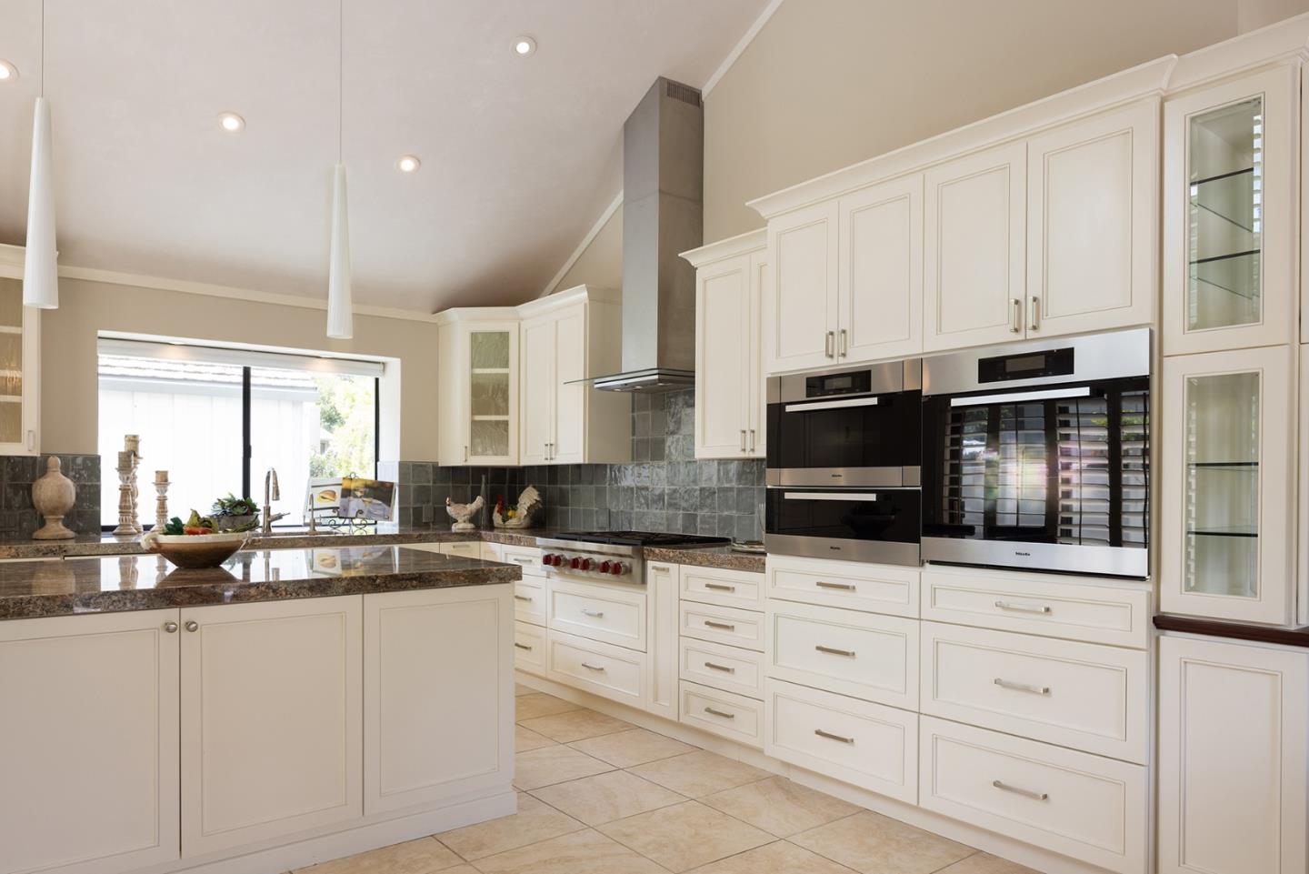 9621 Homestead Road Carmel, CA 93923 - Photo 4 of 30 a kitchen with granite countertop white cabinets and stainless steel appliances