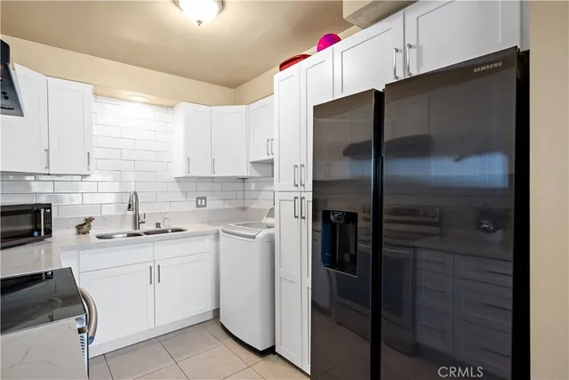 a kitchen with a refrigerator sink and cabinets