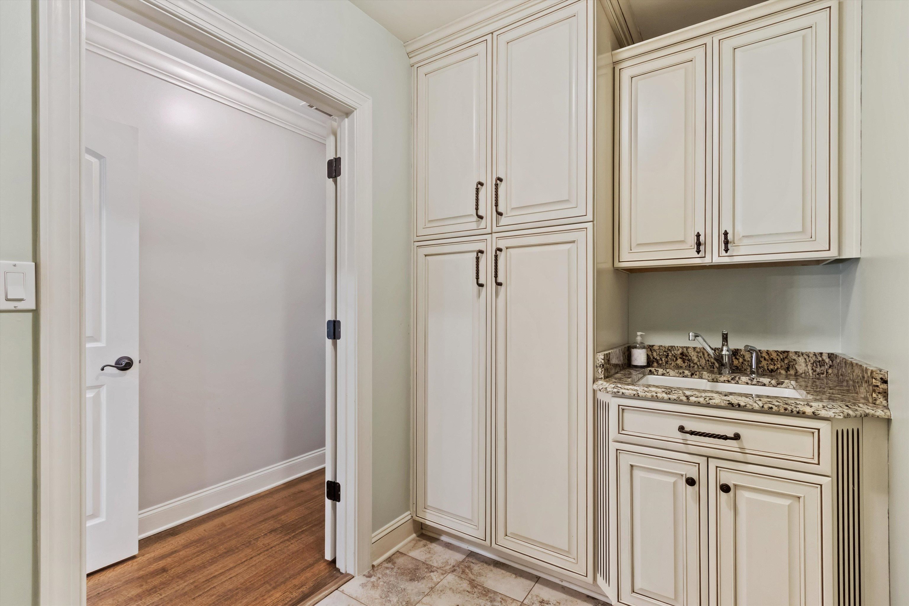 5302 South Angela Road Memphis, TN 38120 - Photo 18 of 40 Custom cabinetry with integrated utility sink and stone countertop